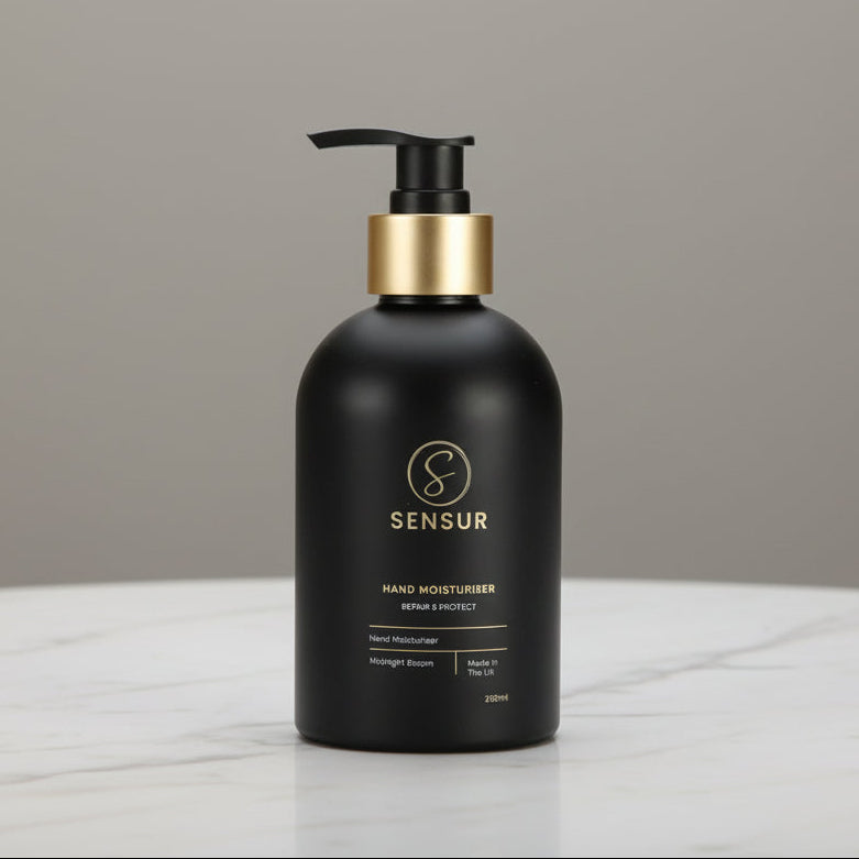 Black hand soap bottle with gold pump on a white background