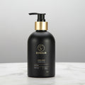 Black soap bottle with gold pump on a white background