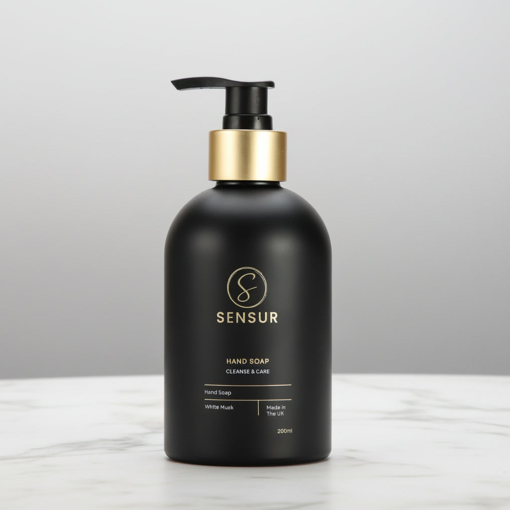 Black soap bottle with gold pump on a white background