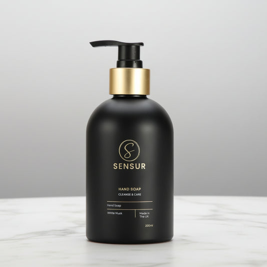 Black soap bottle with gold pump on a white background