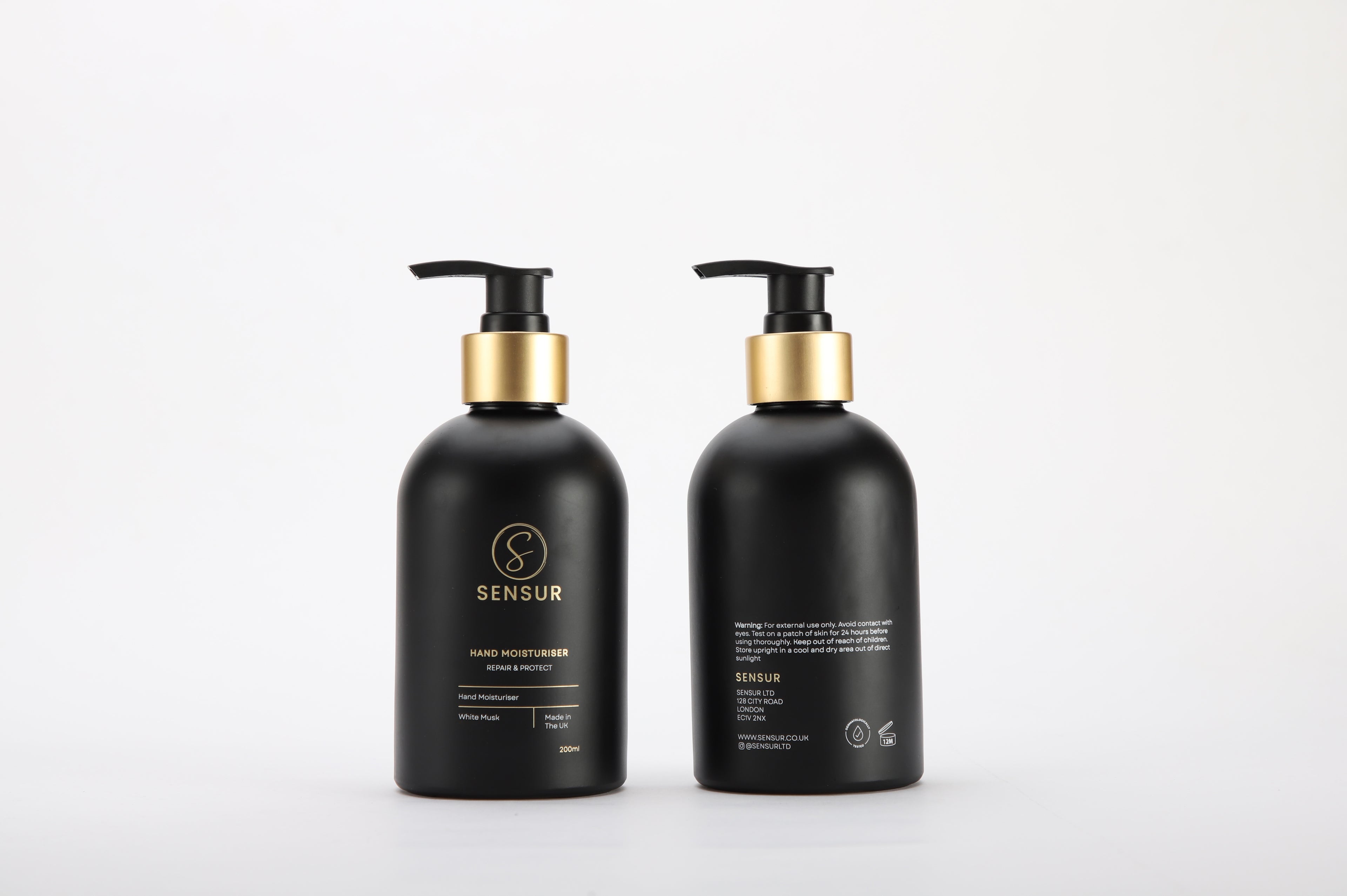Two black bottles with gold pumps on a white background