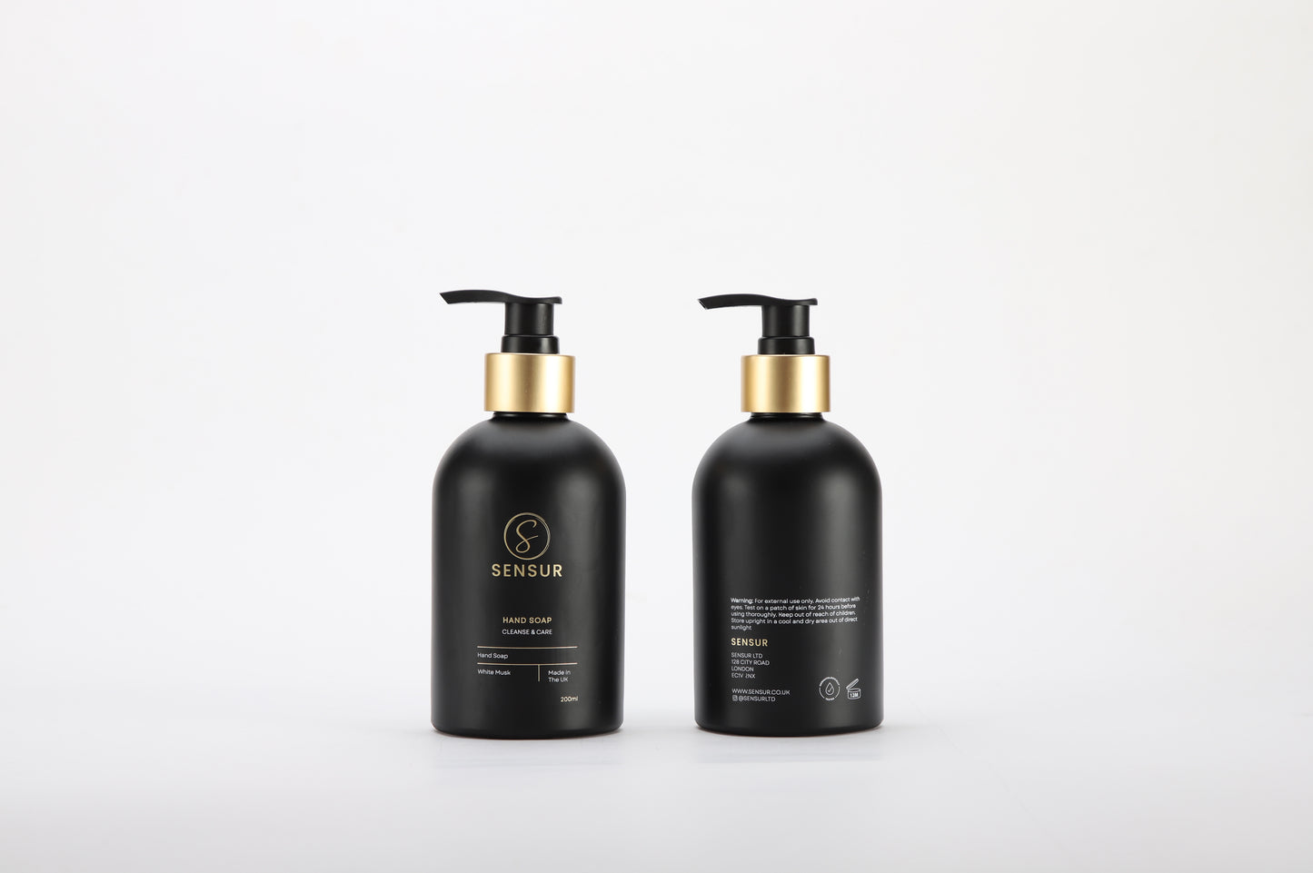 Two black bottles with gold caps on a white background