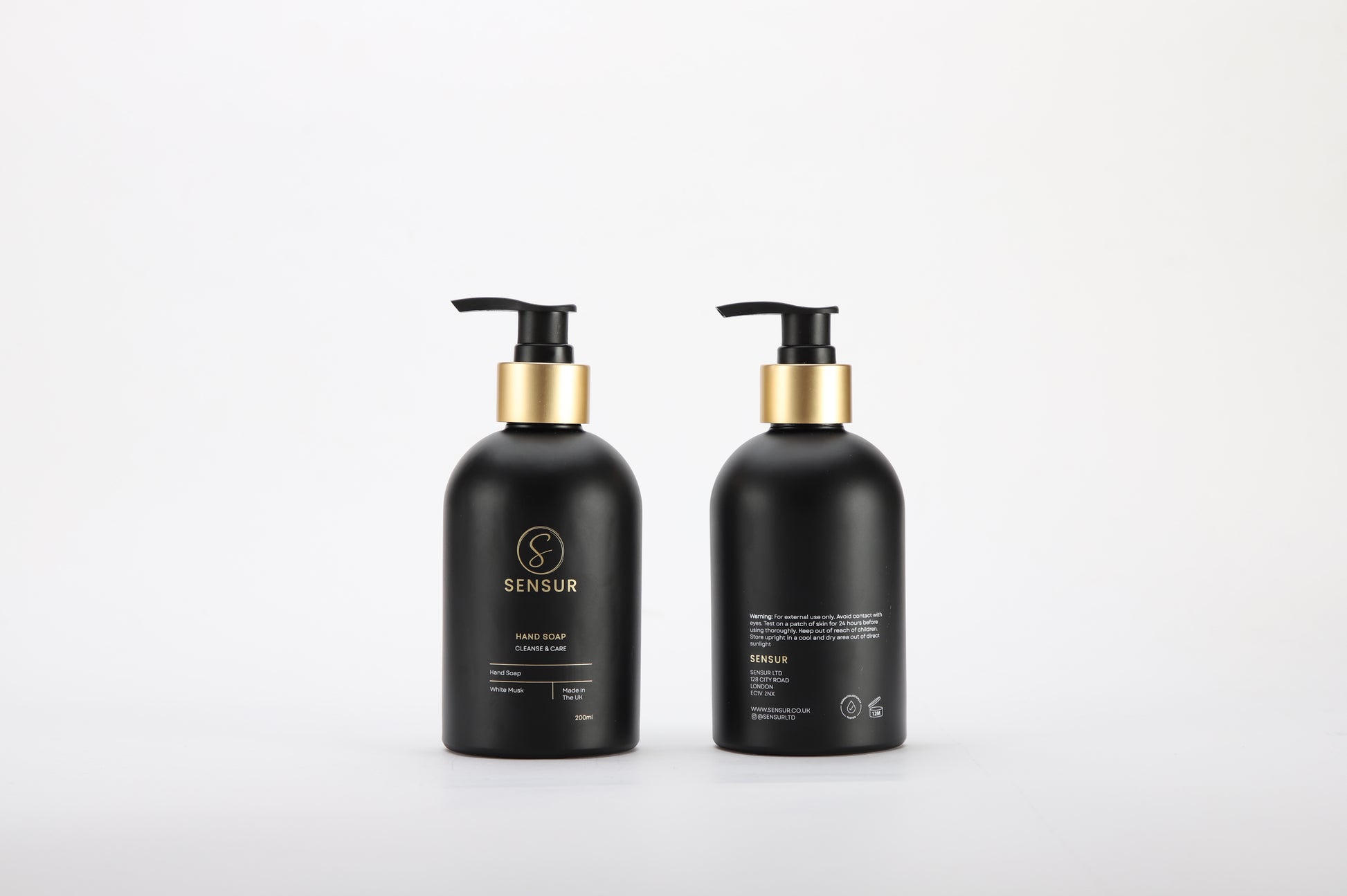 Two black bottles with gold caps on a white background