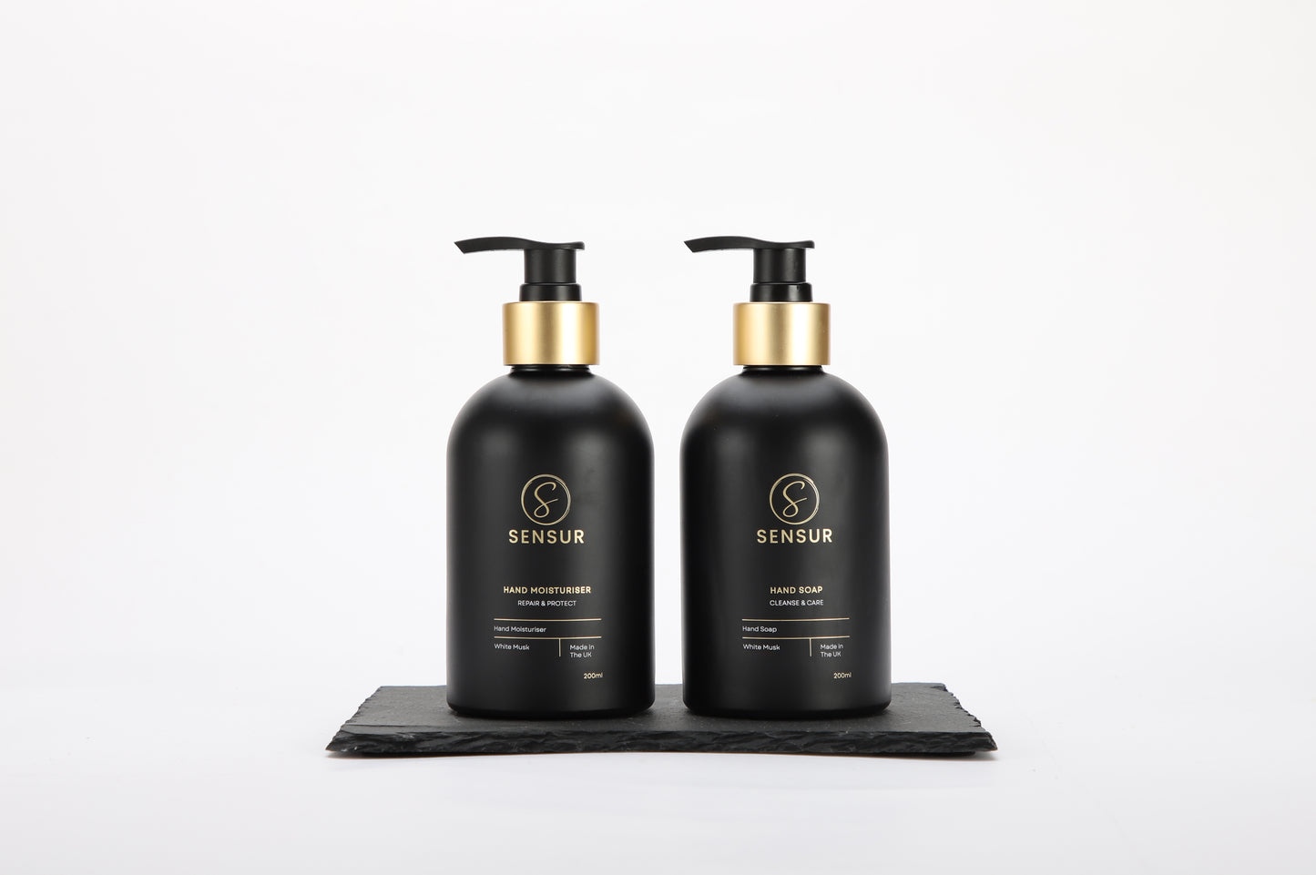 Two black Sensur bottles with gold pumps on a white background