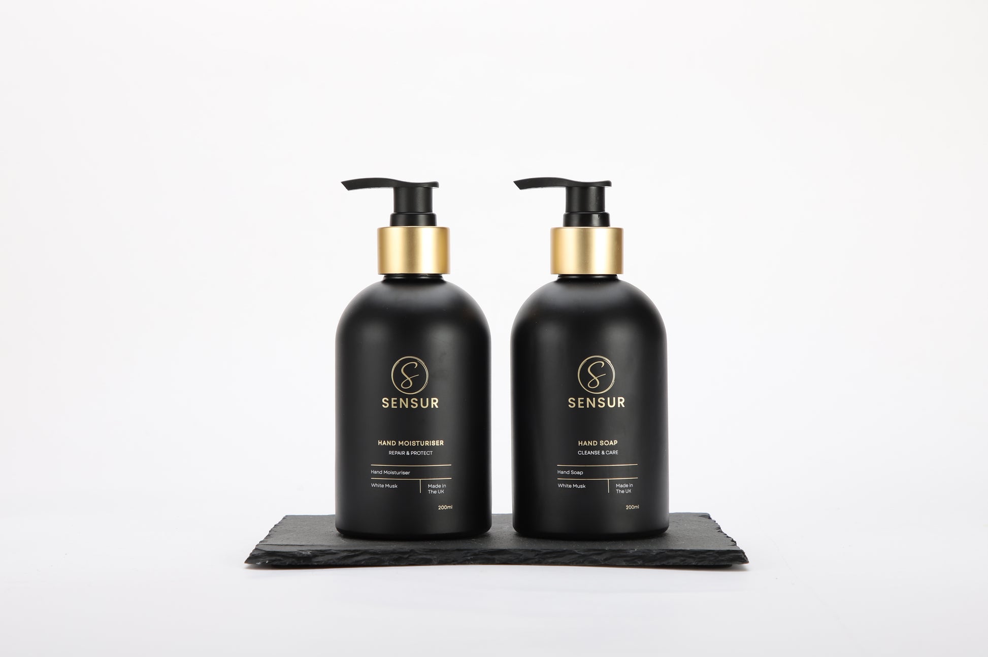 Two black Sensur bottles with gold pumps on a white background