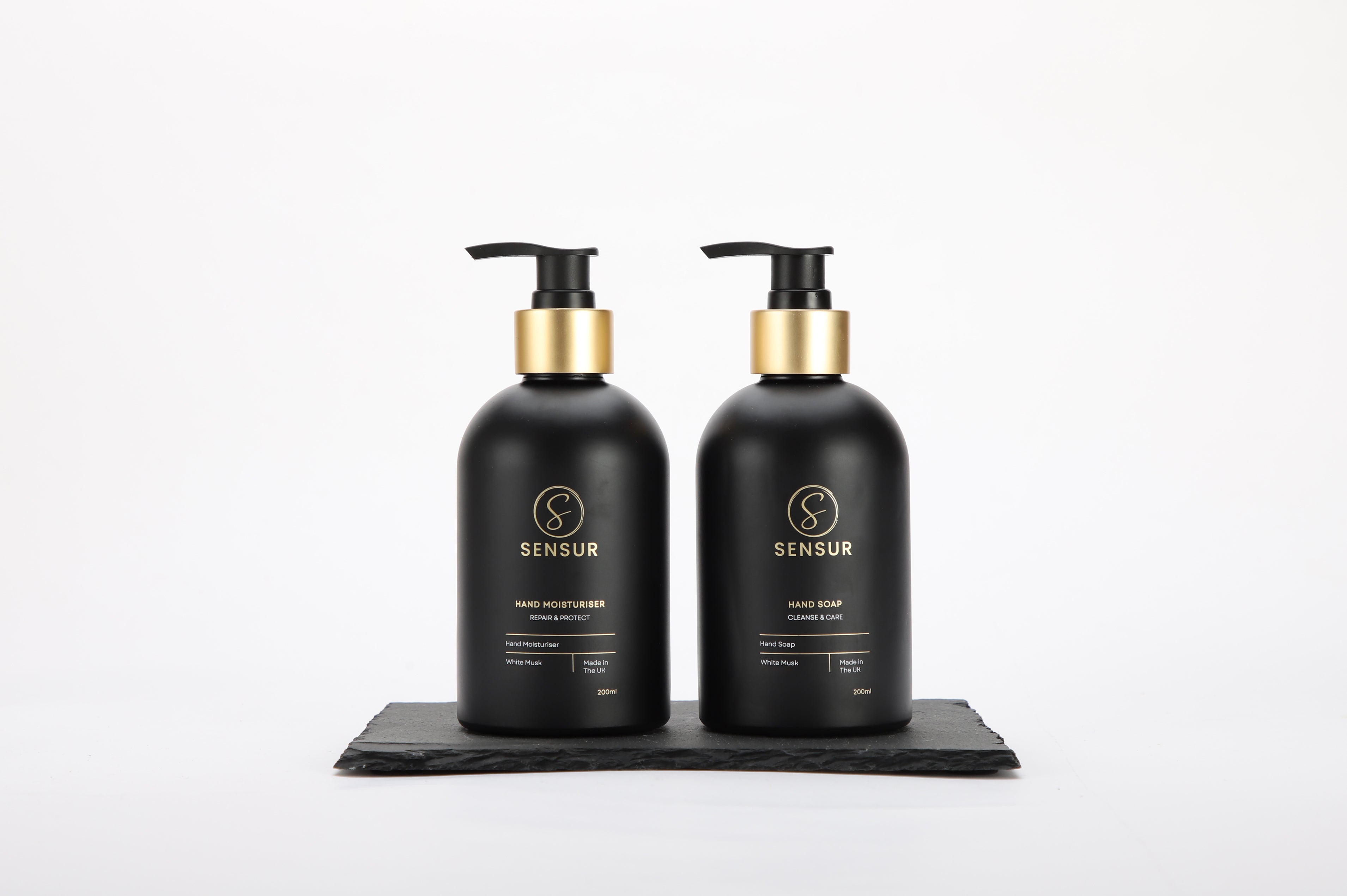 Two black Sensur bottles with gold pumps on a white background